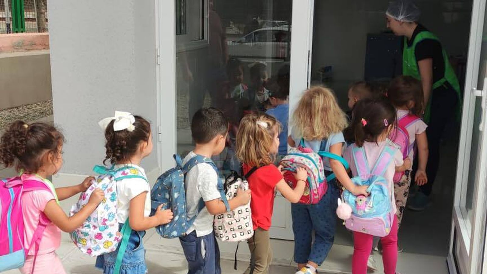 Ilusionados entran por primera vez en u ya comedor escolar.