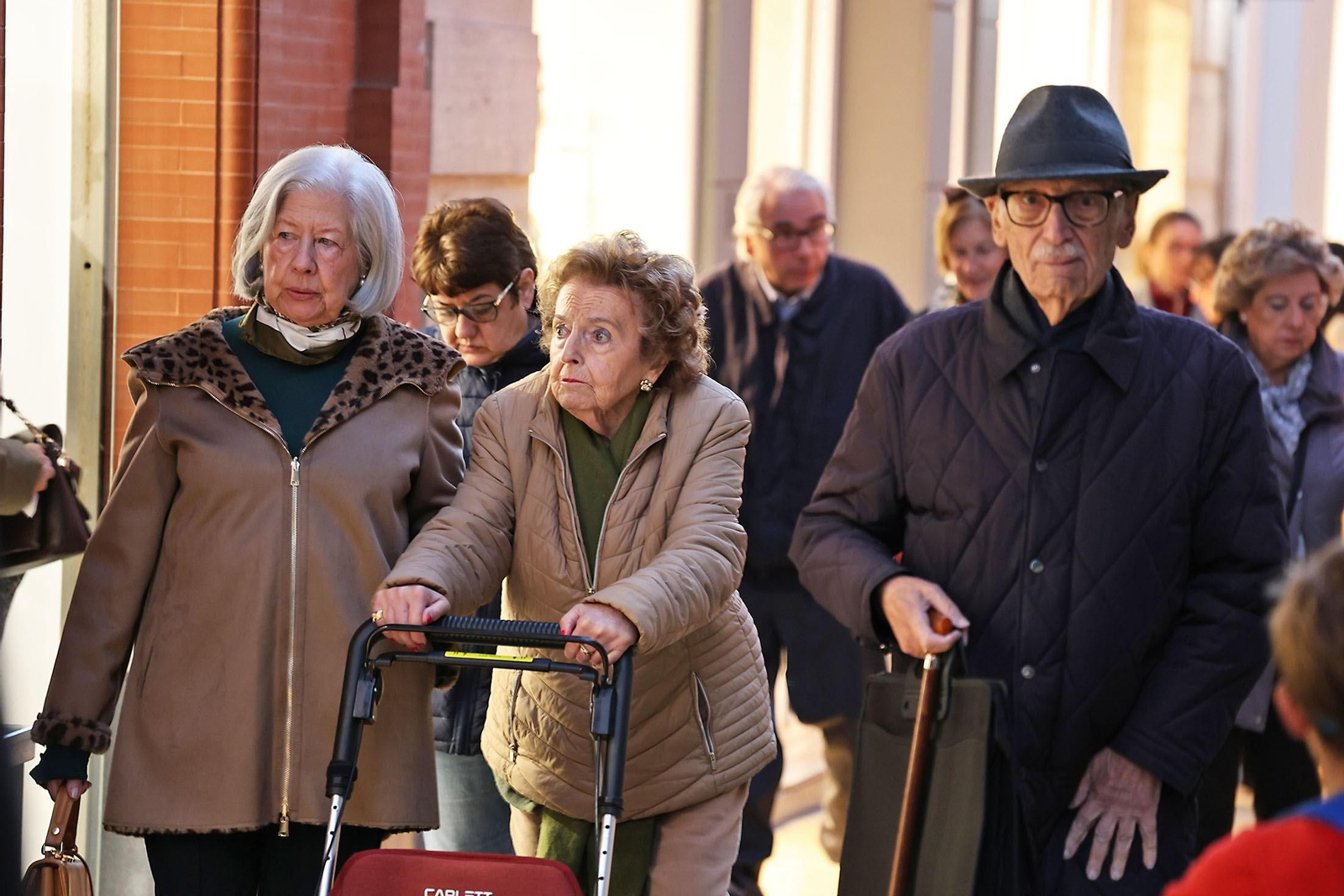 Personas pasean por la calle con abrigos para protegerse del frío.