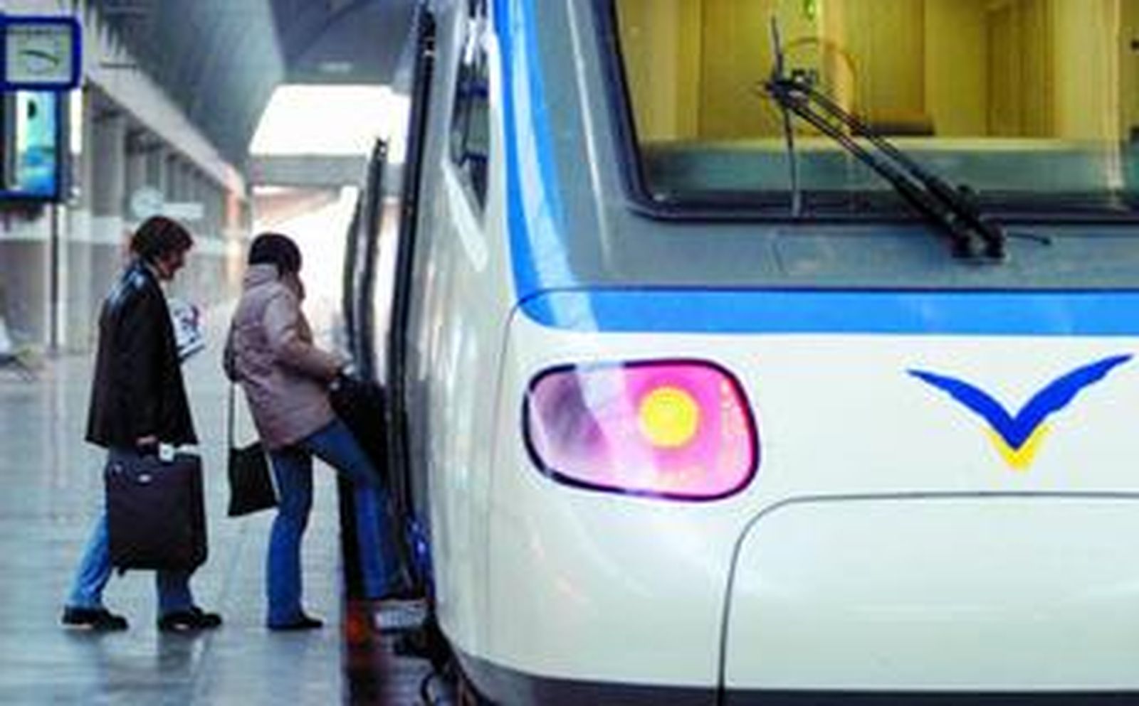 Imagen de dos pasajeros accediendo a uno de las vagones de un AVE.