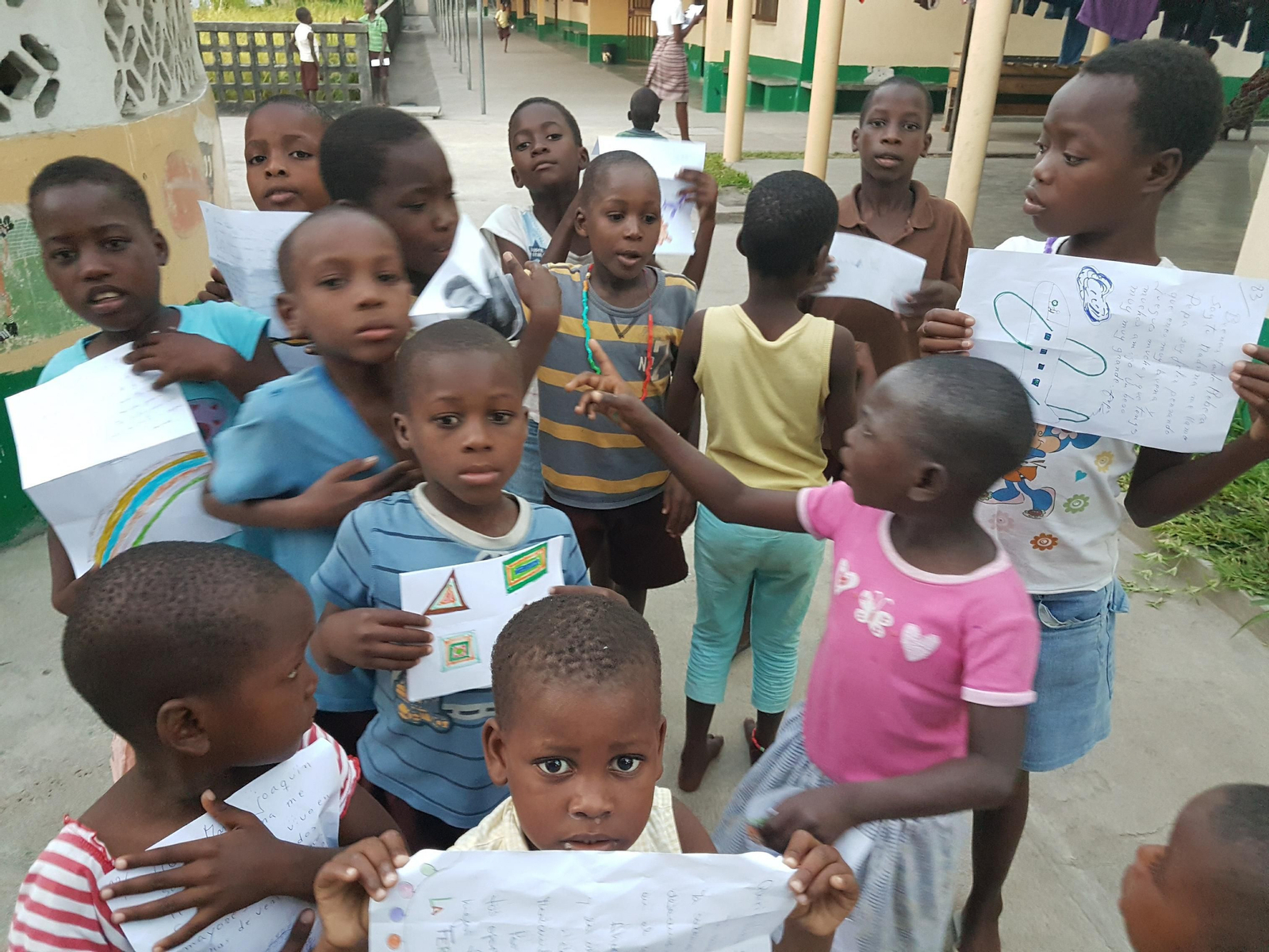 1. Los niños del 'Lar Siloé' enseñan los dibujos que han hecho para sus padrinos y madrinas. 2,3 y 4. Cada año, los más pequeños colorean y dibujan y tienen la oportunidad de comunicarse con las personas que les apadrinan mandándole cartas y dibujos a través de los cooperantes cuando estos viajan allí.
