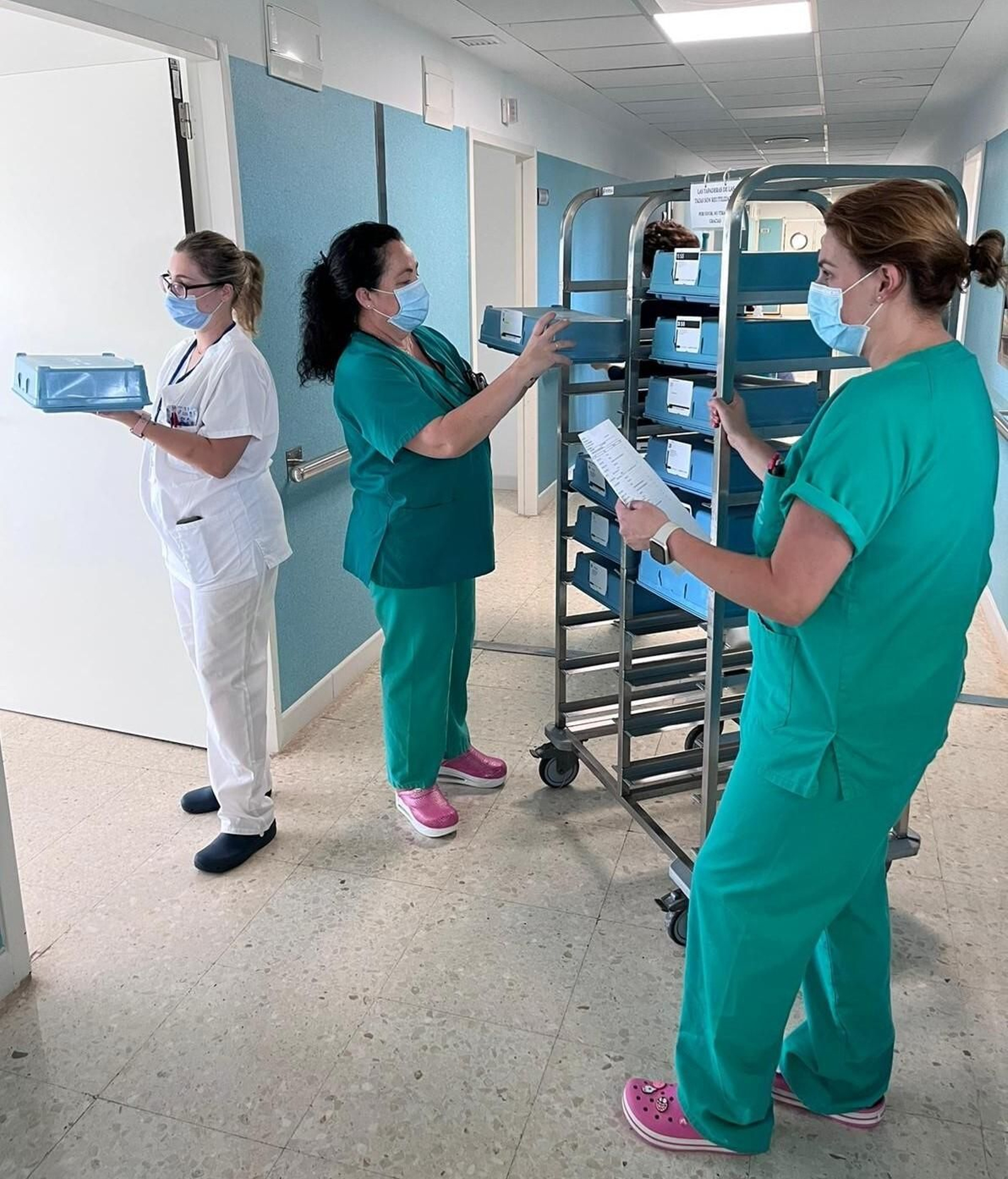 TCAE del hospital Infanta Elena realizan un reparto de bandejas.