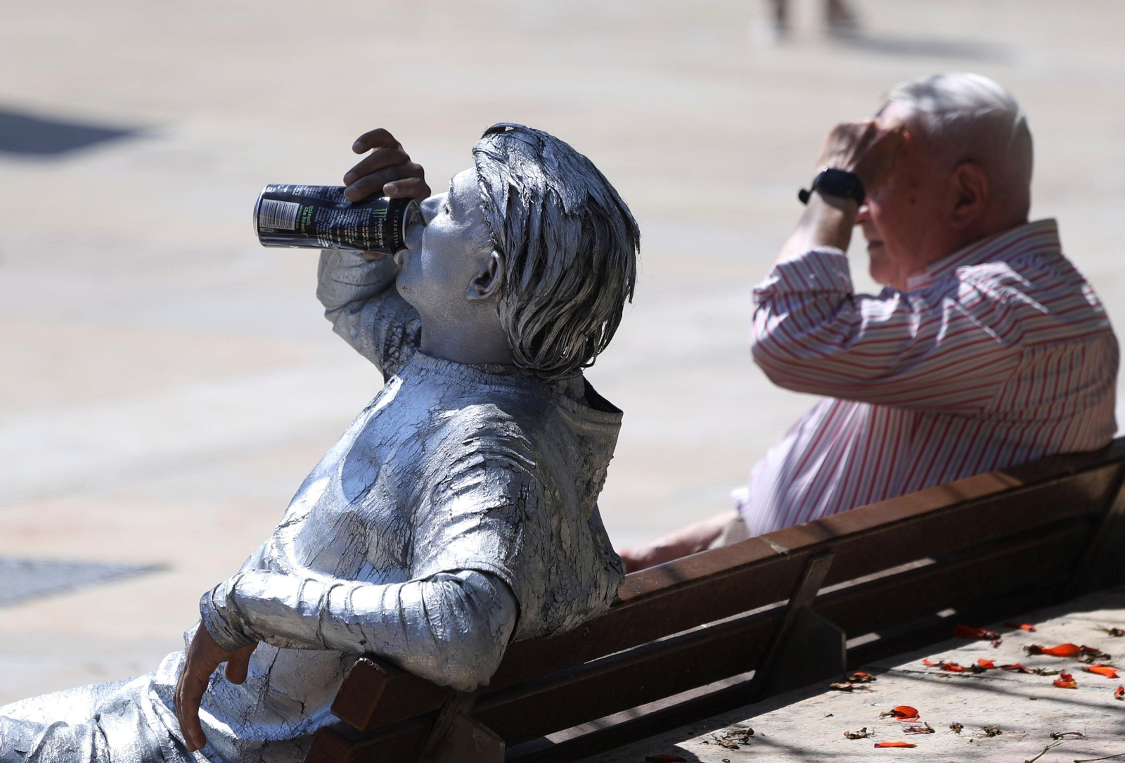 Dos personas descansan en un banco público de Málaga.