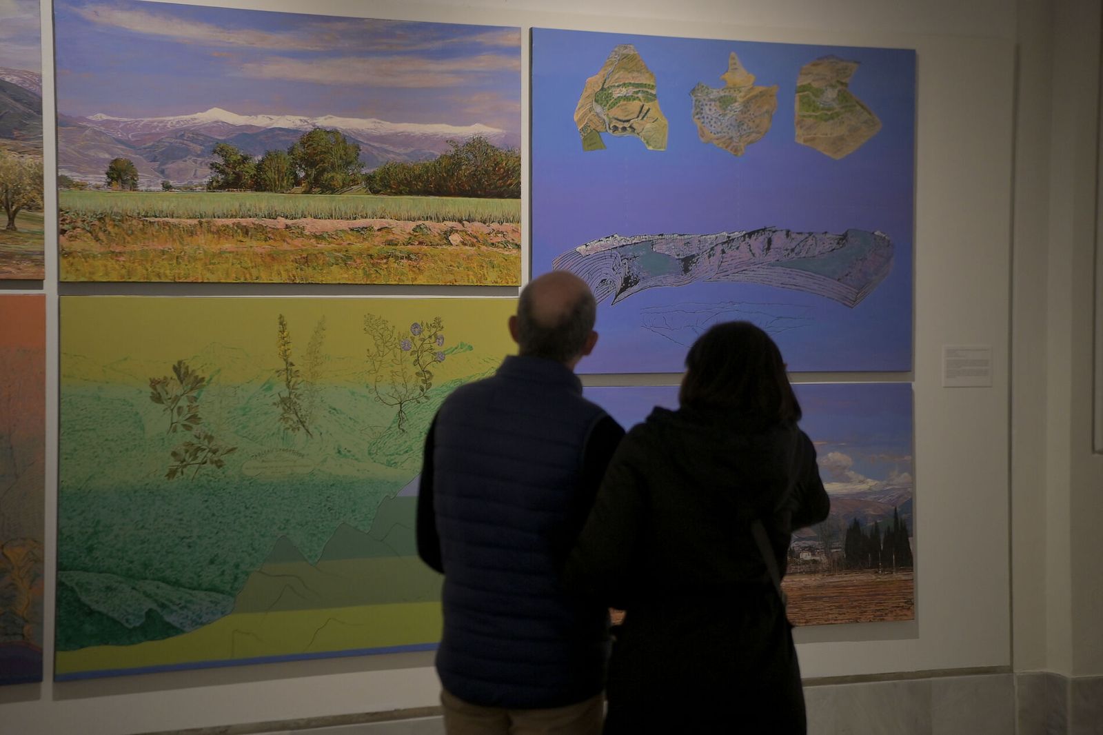 Dos visitantes contemplan las fotos de la muestra de Carreño en Gran Capitán.