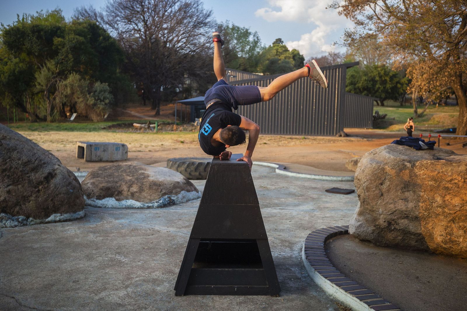 Un joven practica parkour en un parque.