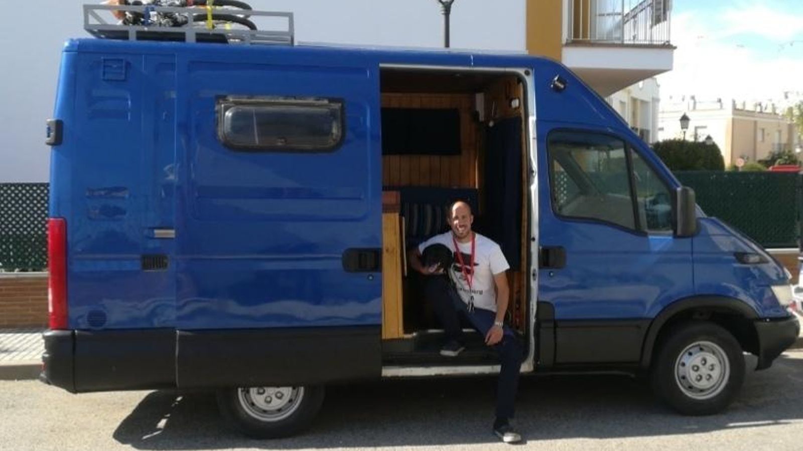 José Sánche posa con su perro y su furgoneta convertida en autocaravana.