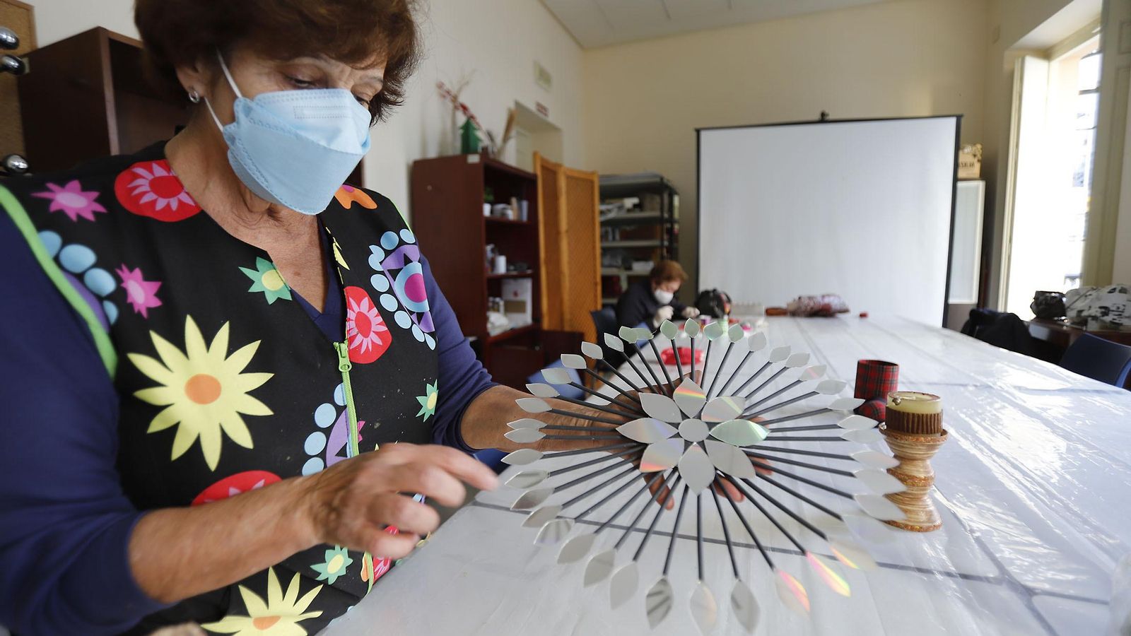 Asunción Fernández es usuaria y voluntaria, imparte el taller de Manualidades y muestra una de sus creaciones.