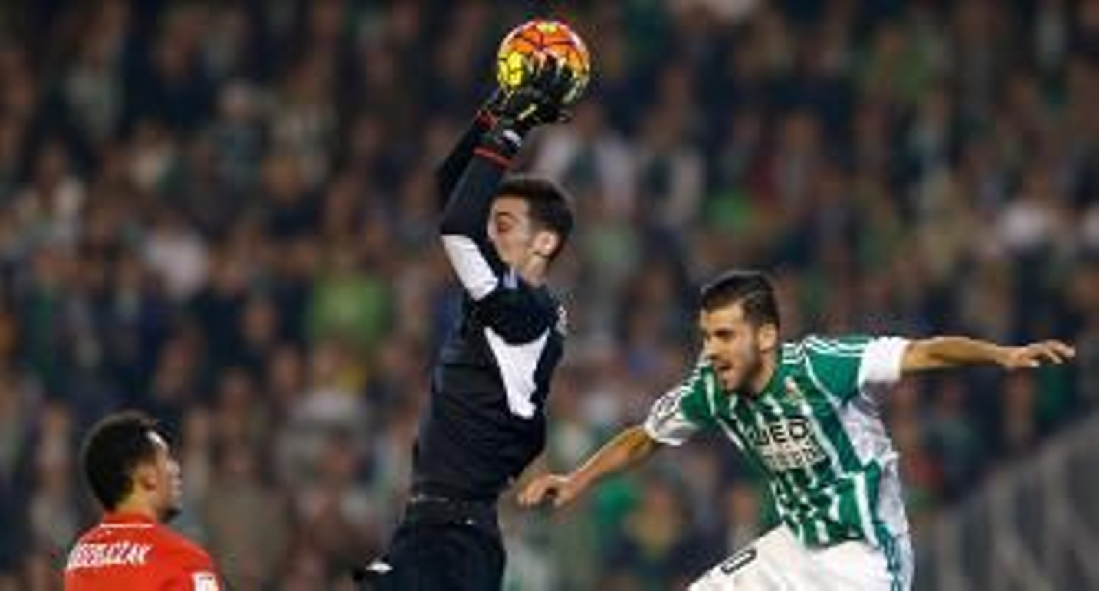 Sergio Rico atrapa un balón aéreo en el derbi ante la presencia de Dani Ceballos. / EFE