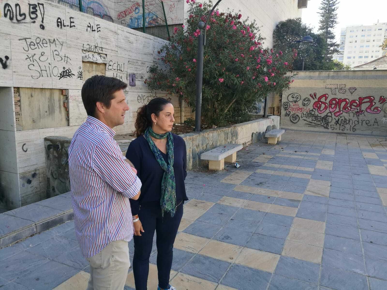Los ediles de Ciudadanos Guillermo García de Longoria y Noelia Álvarez, en la Plaza de Cine, junto a la Casa Colón, llena de pintadas y destrozos.
