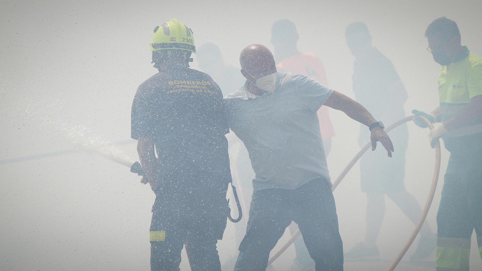 Bomberos y vecinos se afanan en detener el fuego.