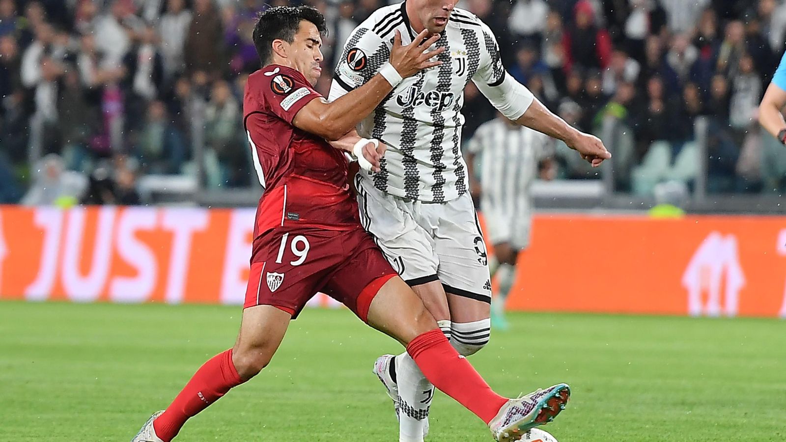 Acuña forcejea con Vlahovic para robarle un balón al serbio.