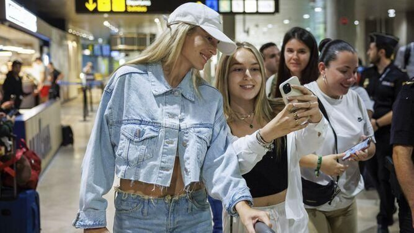Alexia Putellas atiende a una aficionada a su llegada al aeropuerto de Valencia.