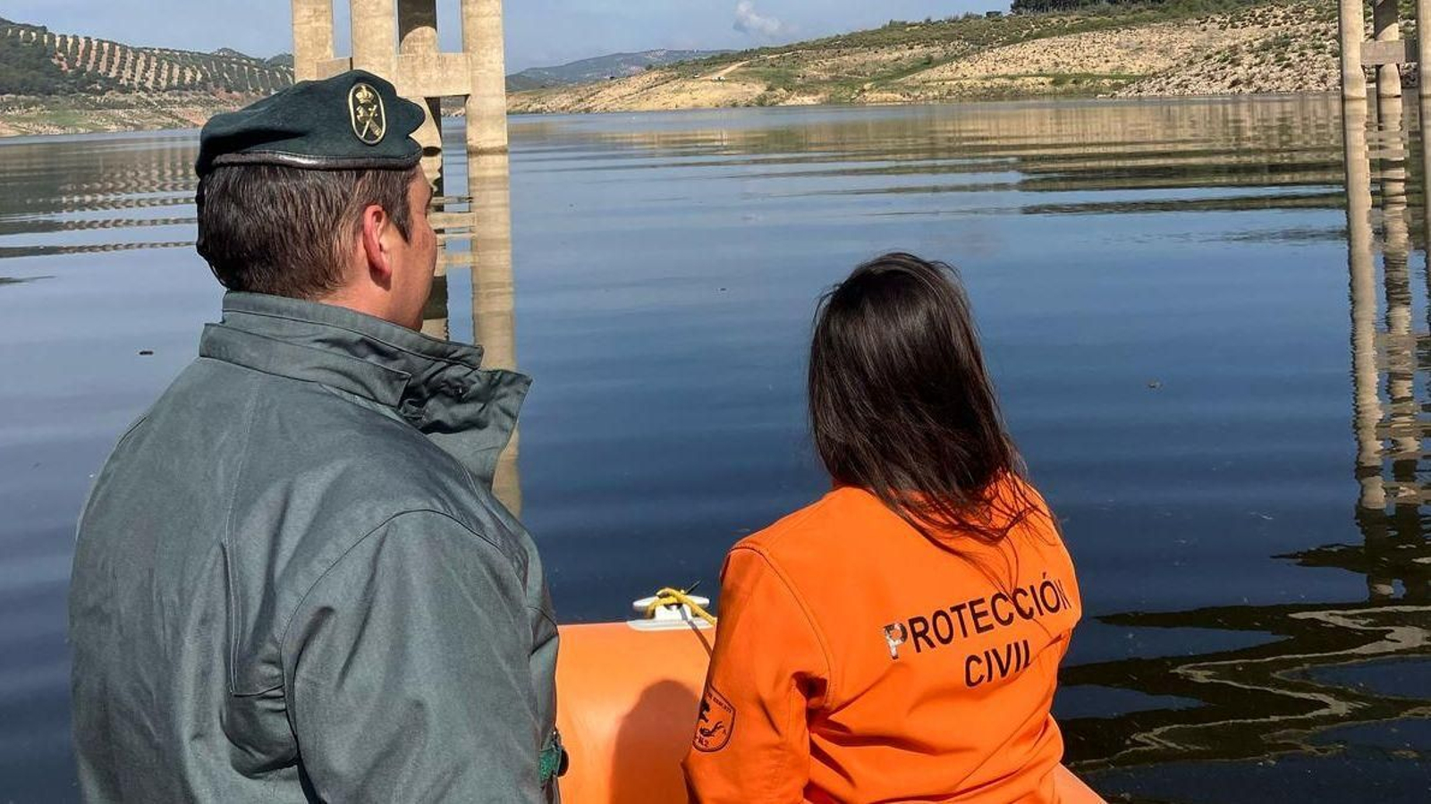 Un agente del Seprona con un integrante de Protección Civil en el embalse de Iznájar