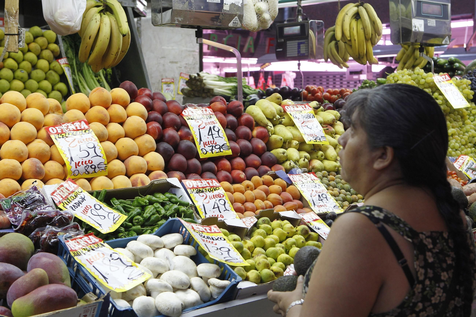 Una mujer comprueba los precios en una frutería