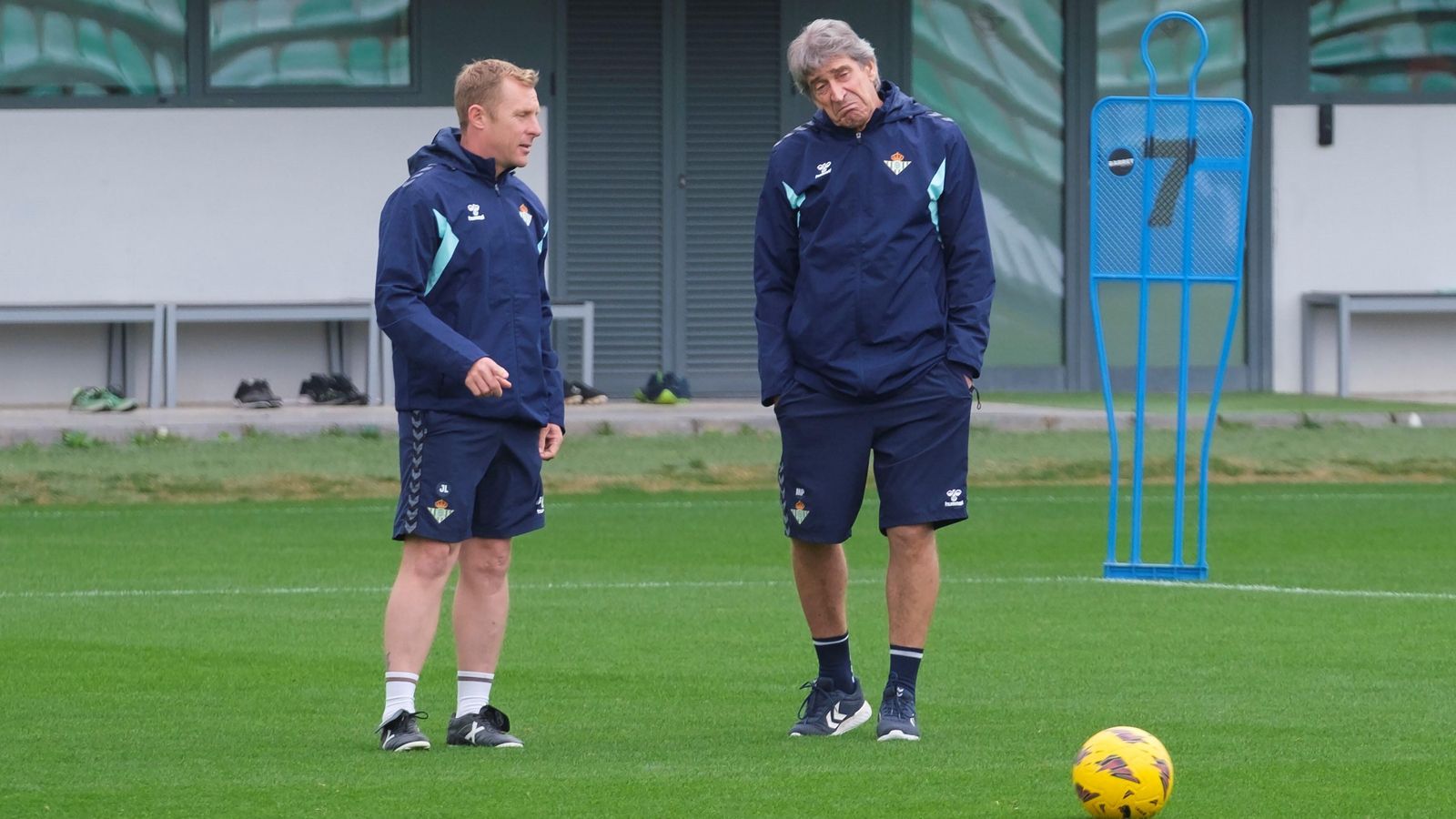 Manuel Pellegrini, sobre el césped de la ciudad deportiva junto a uno de sus colaboradores.