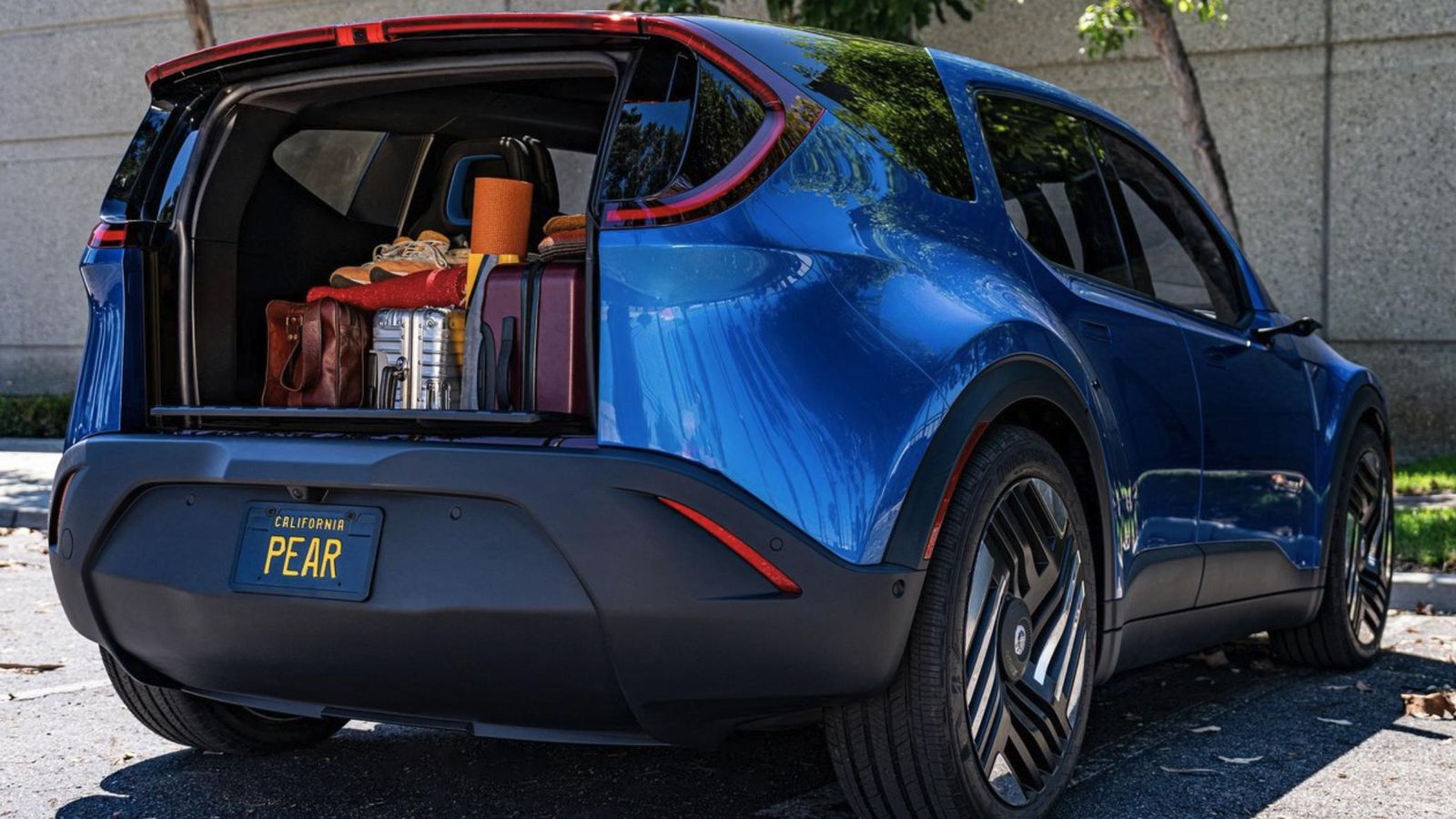 El portón trasero, abierto, queda oculto tras el parachoques posterior en el Pear, lo que permite no necesitar espacio tras el coche para acceder a la carga.