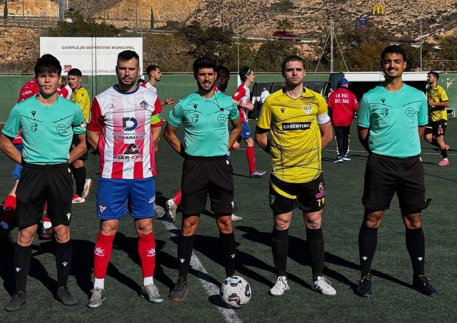 Los capitanes del Poli Almería y Cantoria posan con el trío arbitral antes del comienzo del derbi almeriense.