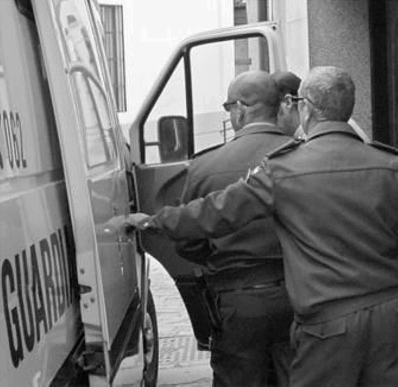 El detenido es conducido a un furgón policial tras ser decretado su ingreso en prisión.