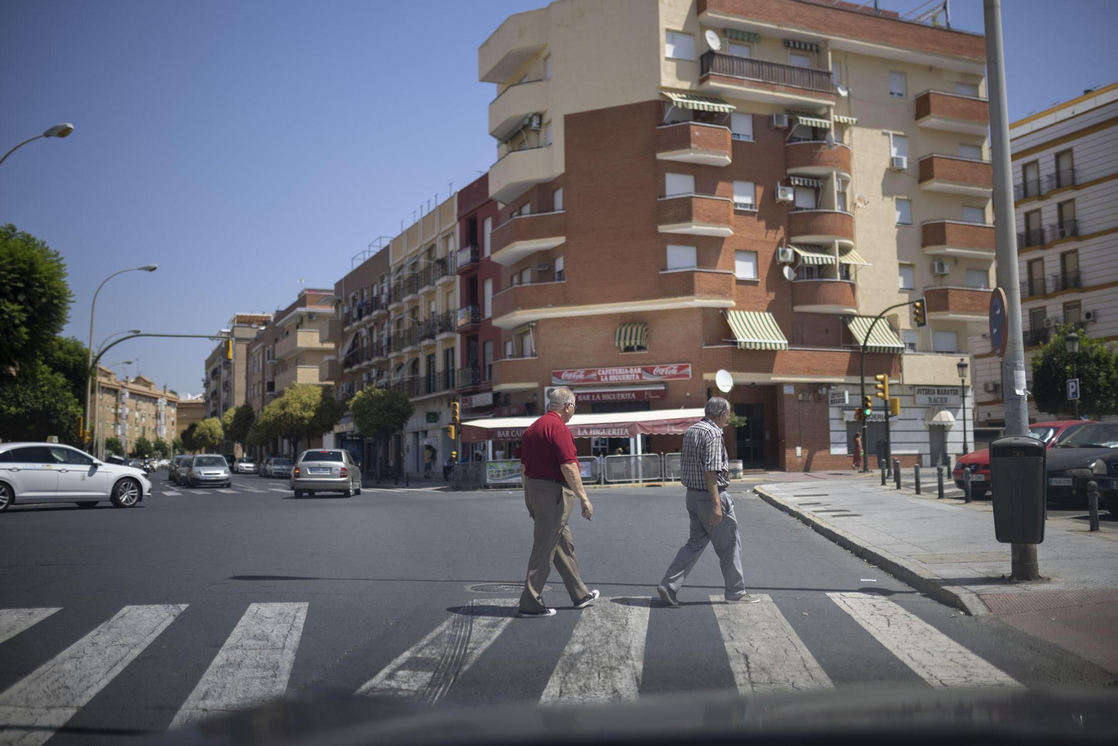 Dos onubenses cruzan un paso de peatones.