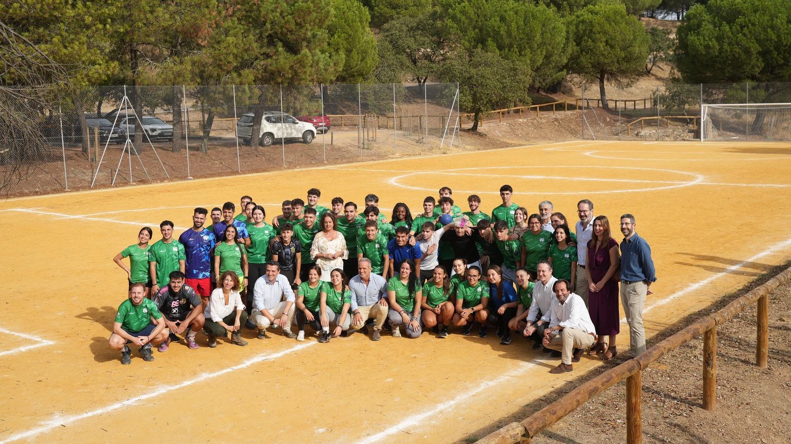 Dirigentes institucionales posan con un equipo en una pista deportiva de Los Villares.