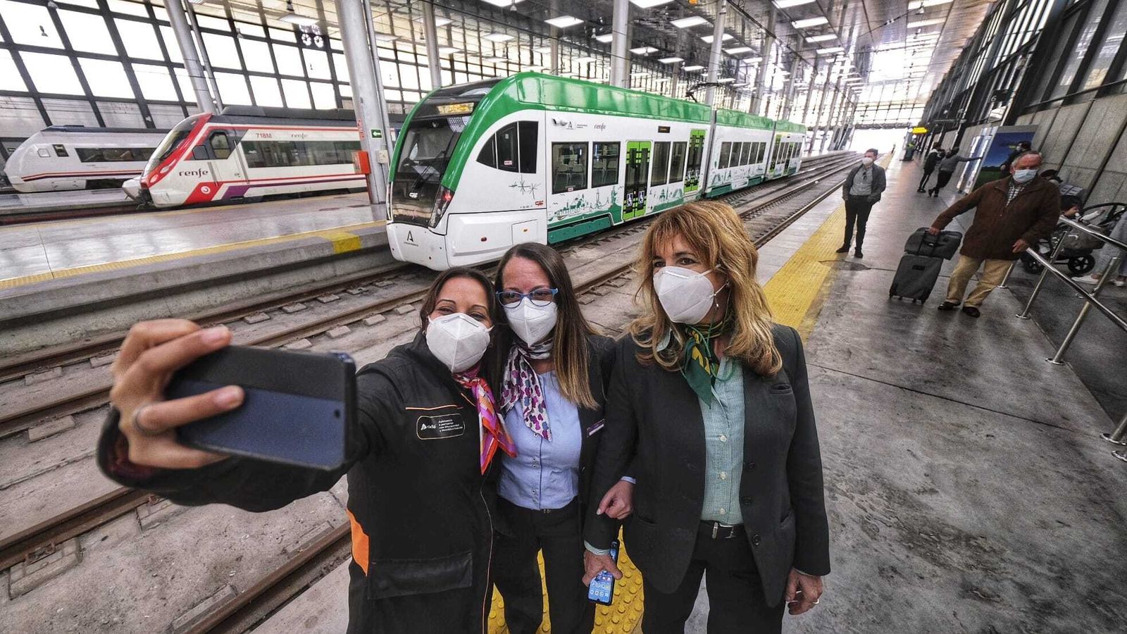Foto de la familia ferroviaria con el nuevo tranvía al fondo, en la estación de Cádiz.
