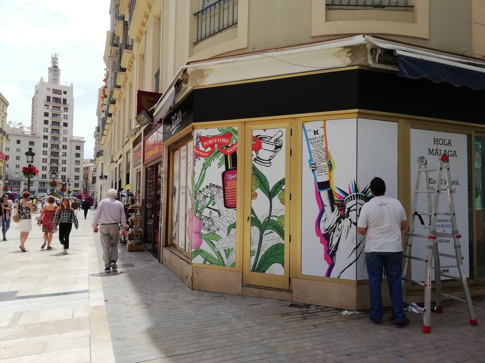 Un trabajador coloca los carteles en los que se anuncia la próxima apertura de Kiehl's en el local de la calle Larios.