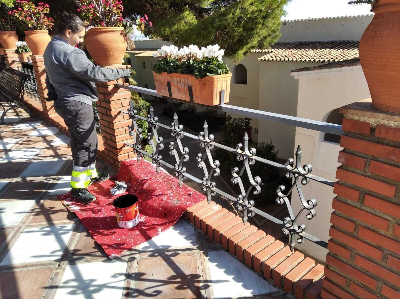 Una operaria realizando trabajos de pintura en la barandilla de la avenida Juan Luis Peralta.