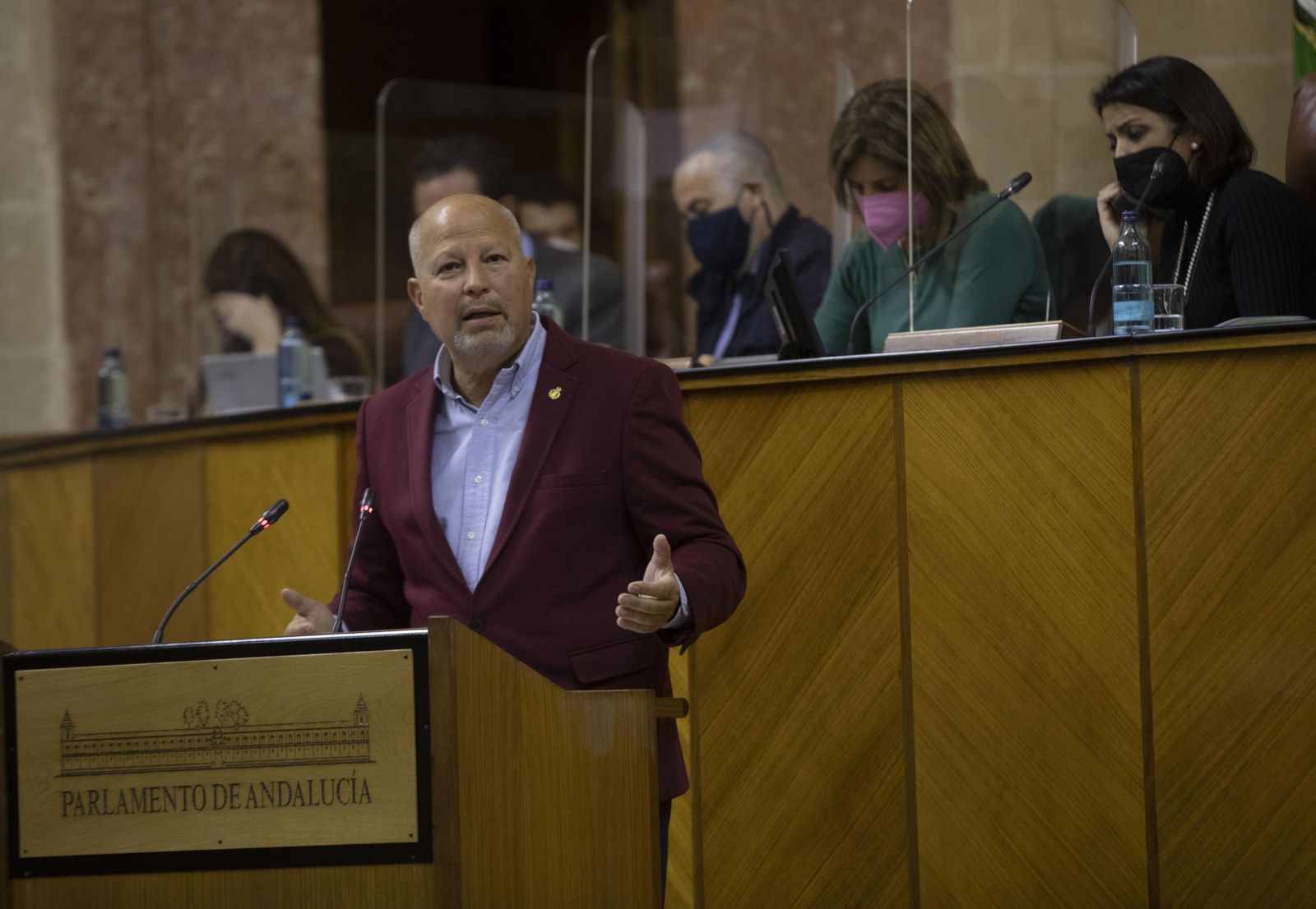 Javier Imbroda en la tribuna del Parlamento. Detrás, con mascarilla rosa, Esperanza Oña.