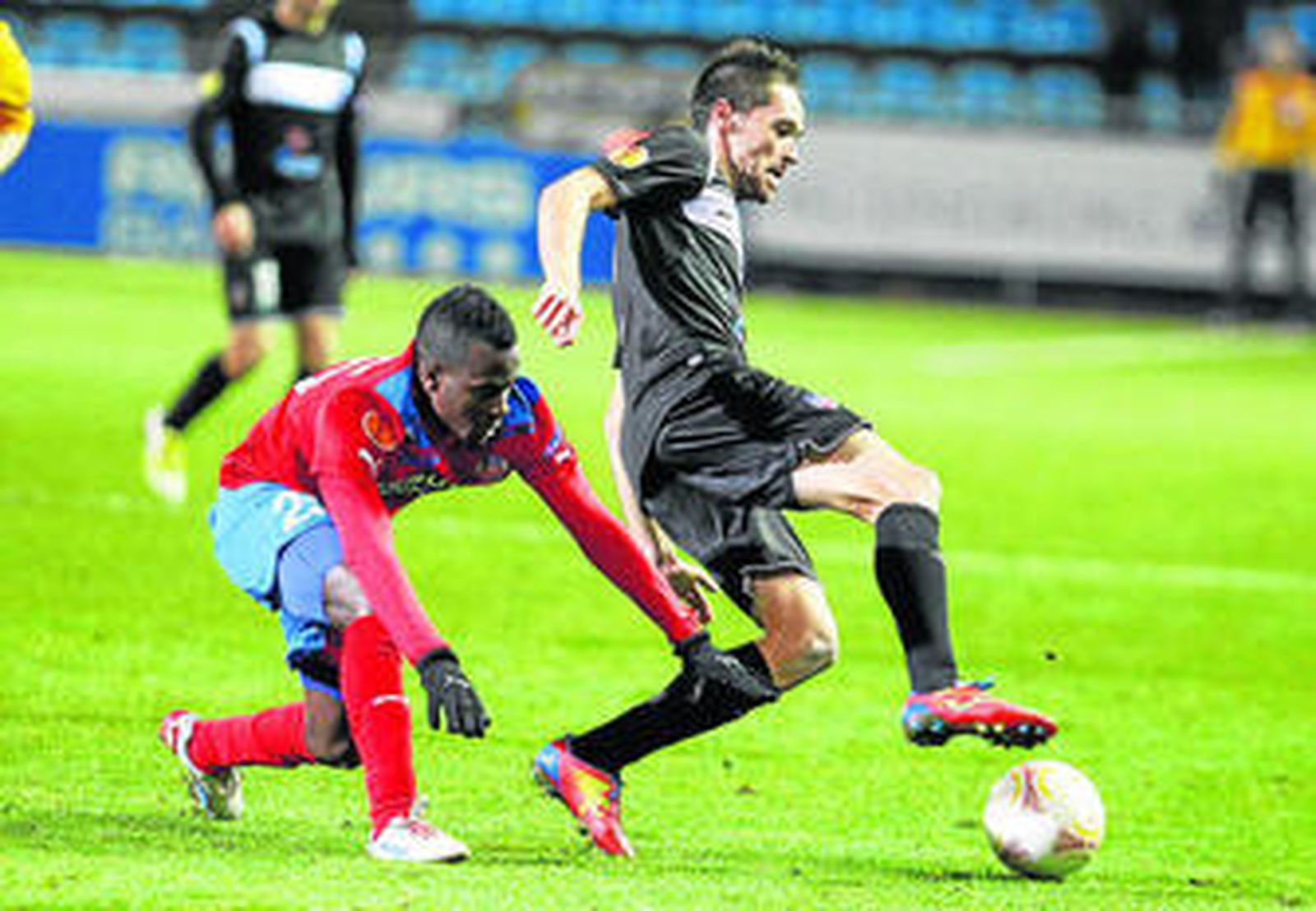 El jugador del Levante Míchel se lleva el balón ante la presencia de Accam.