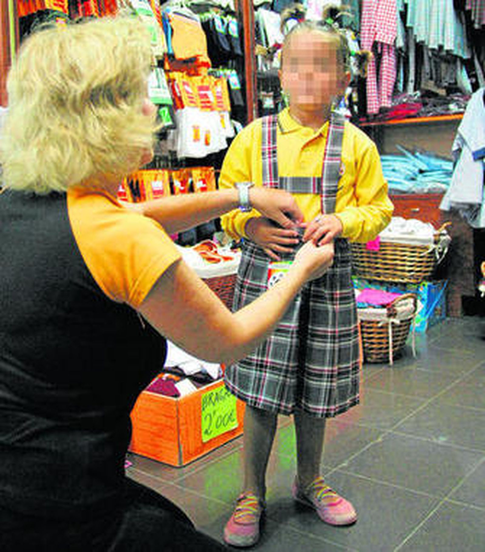 Una niña se prueba un uniforme en una imagen de archivo.