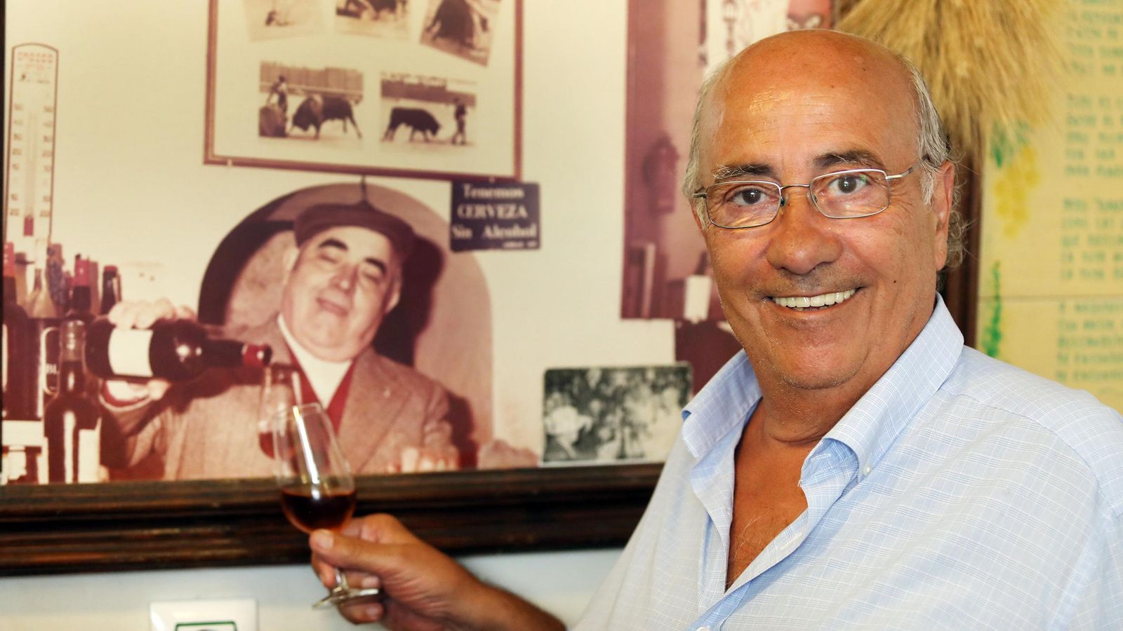 Simpática foto de Faustino Rodríguez junto a una foto de su padre en la que parece servirle una copa de jerez.