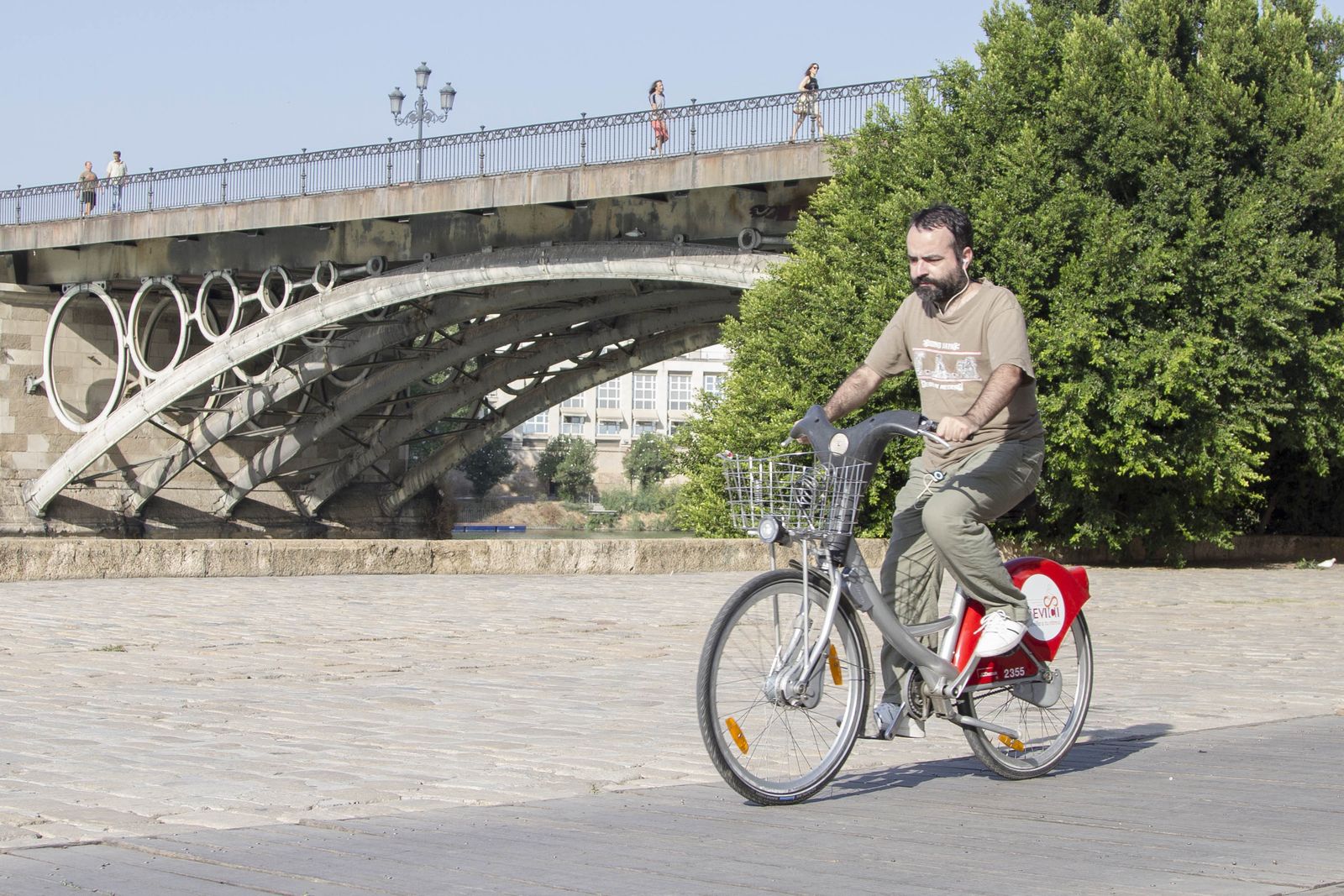 1. Uno de los usuarios de la bicicleta en el paseo junto al río.  2. Un coche eléctrico durante una acción promocional en la Plaza de España.