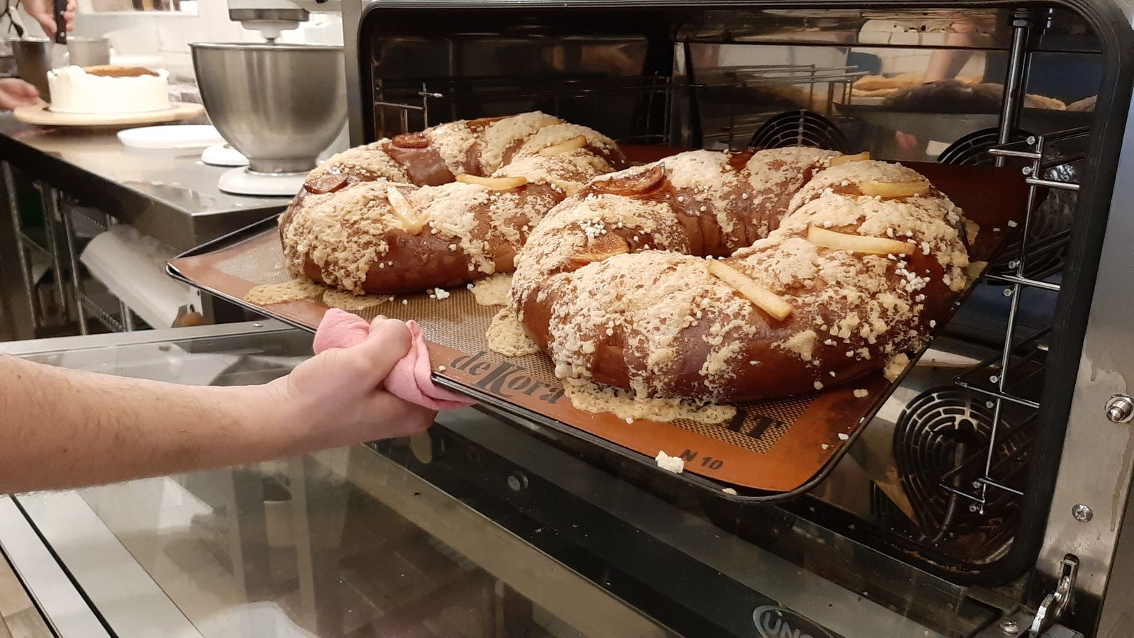 Rafael García saca del horno dos roscones.