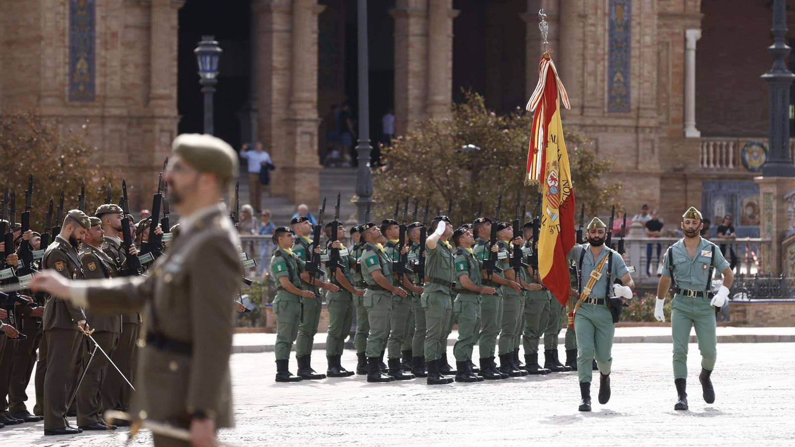 Dos legionarios portan la bandera nacional durante el acto de despedida del general Rodríguez.