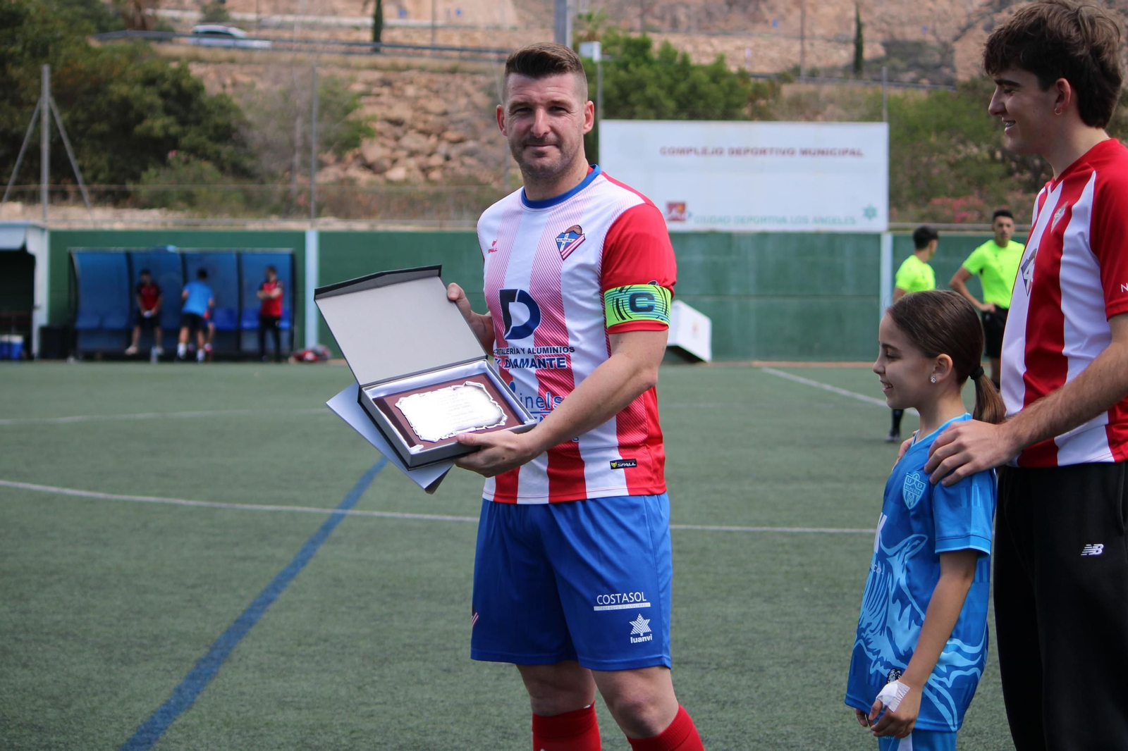 Campanas posa con la placa recibida antes del comienzo del encuentro como reconocimiento a su trayectoria futbolística.