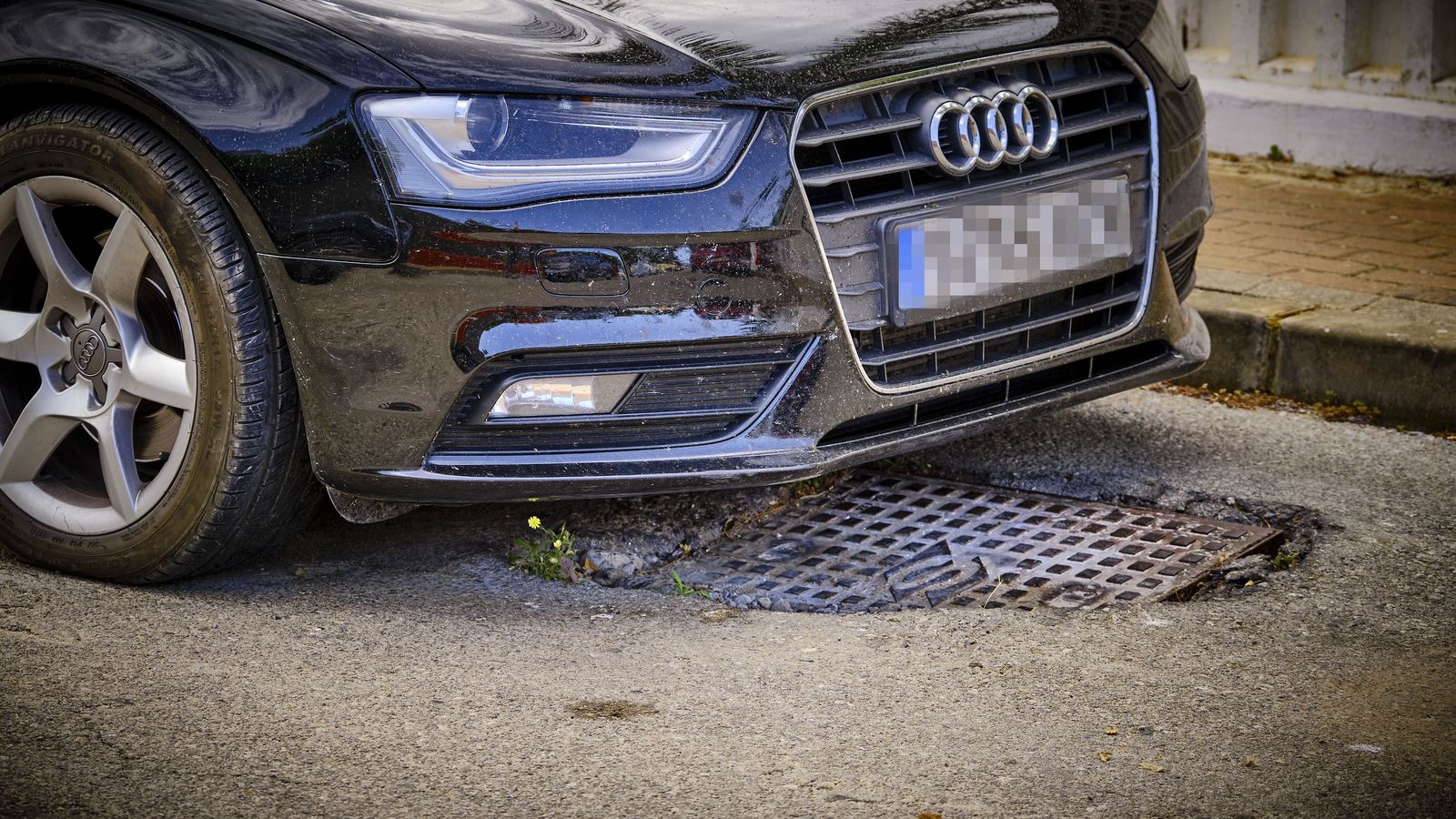 Una peligrosa arqueta semi hundida en una calle de la urbanización.