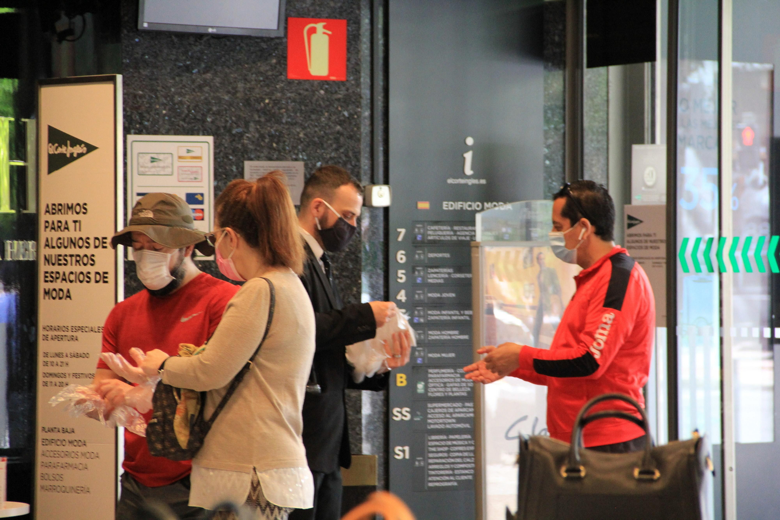 Reparto de guantes en la puerta de un centro de El Corte Inglés.