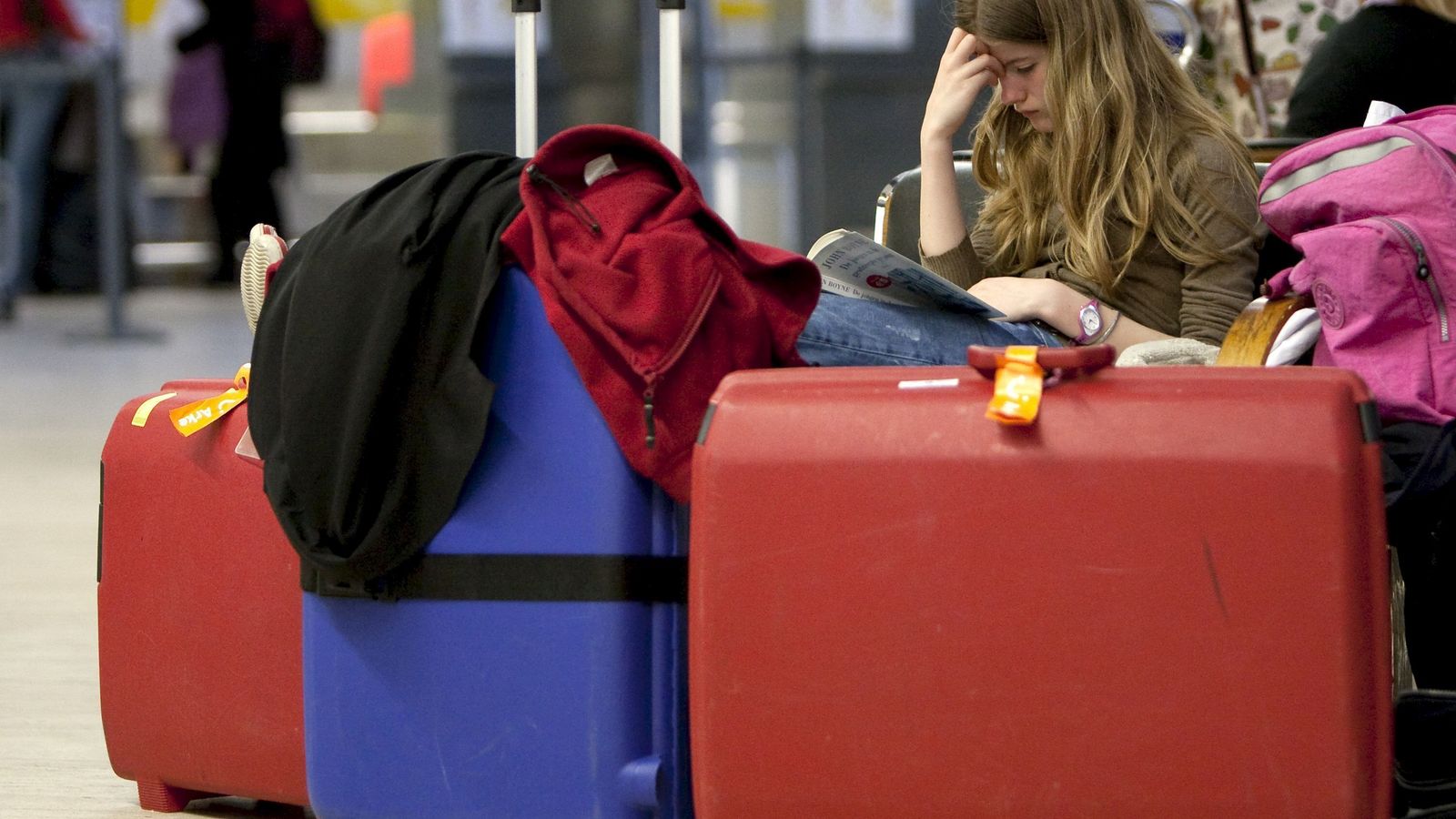 Una joven aguarda en el aeropuerto de Sevilla junto a varias maletas.