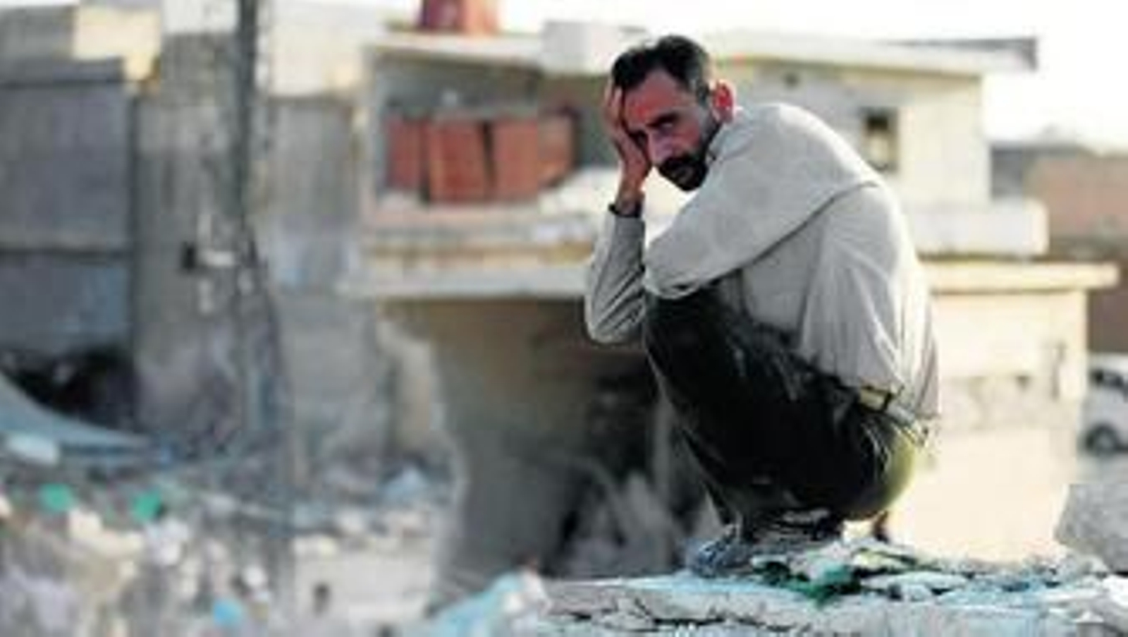 Un hombre se lamenta en silencio sobre los escombros de su casa tras el ataque aéreo efectuado ayer por los aviones gubernamentales sobre la localidad de Azaz.