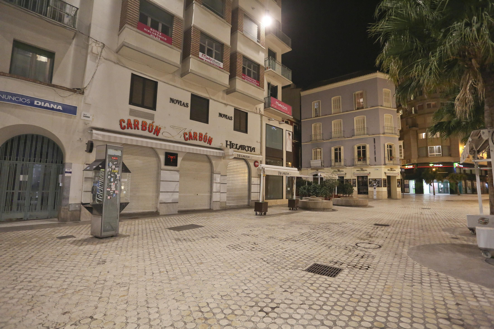 El coronavirus dibuja una noche desierta en el centro de Málaga, en fotos