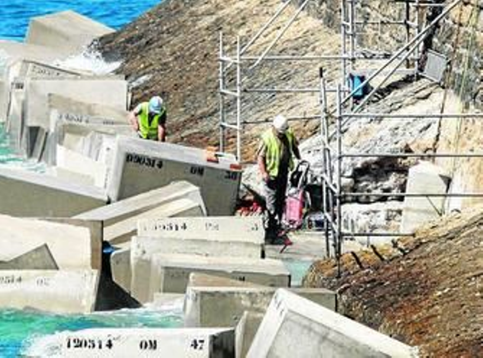 Unos obreros trabajan en la reparación de la muralla en el paseo de Santa Bárbara.
