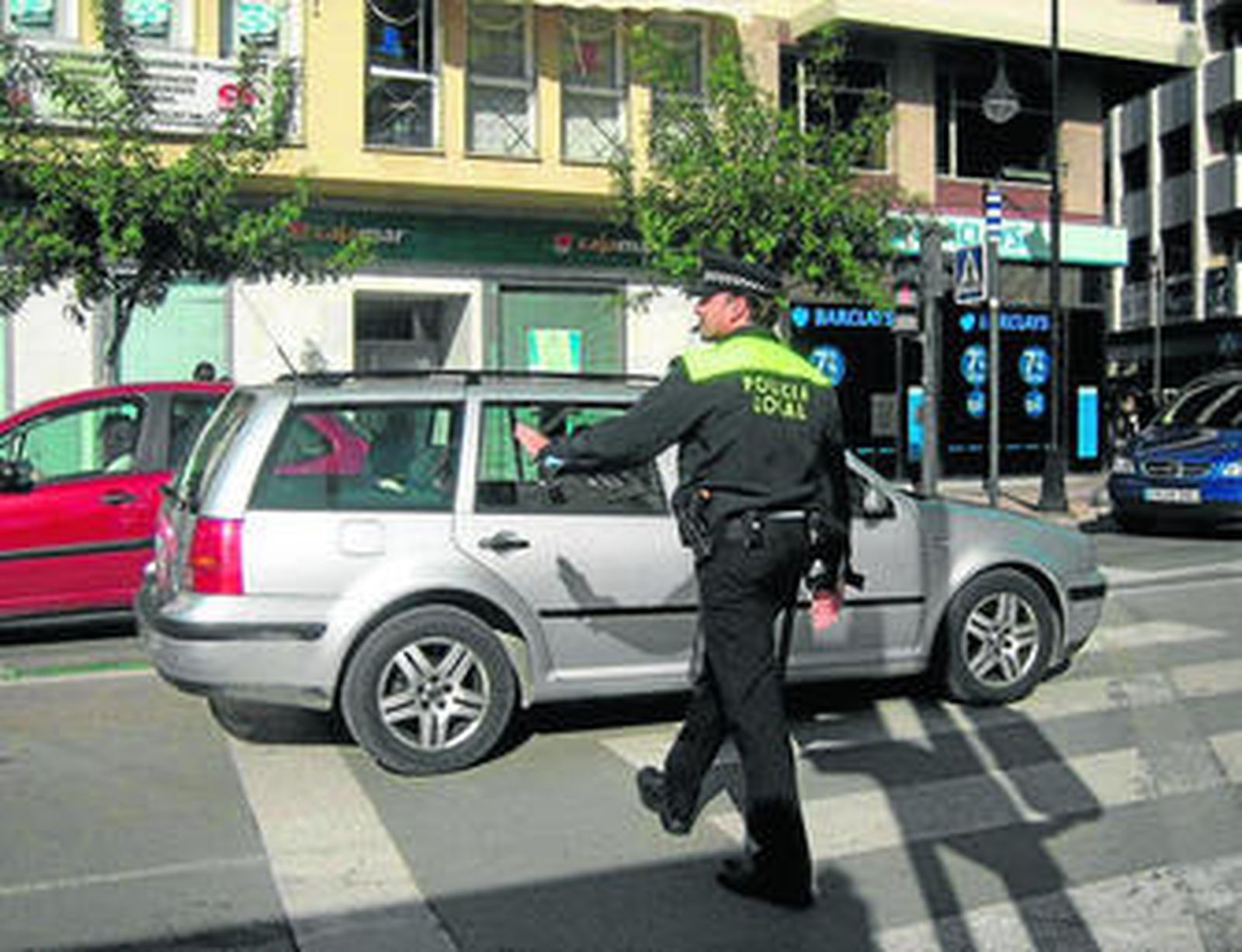 Un agente de la Policía Local de Estepona, dando el alto a un vehículo.