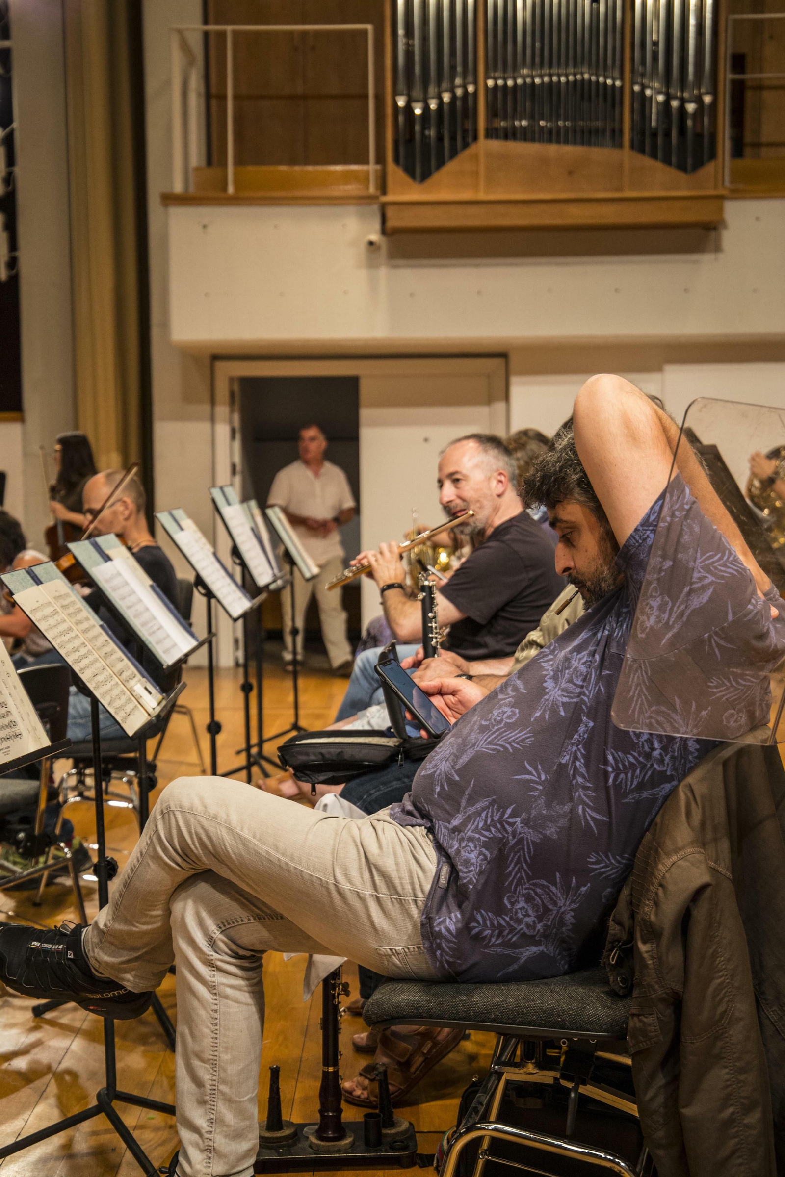 Uno de los músicos mira el móvil en un respiro de los ensayos.
