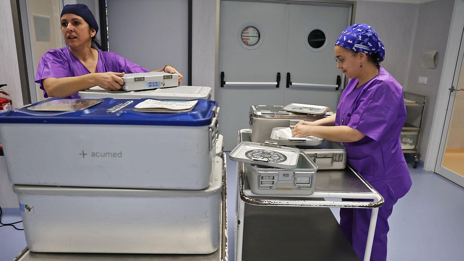 Dos profesionales organizan las cajas con el material quirúrgico.