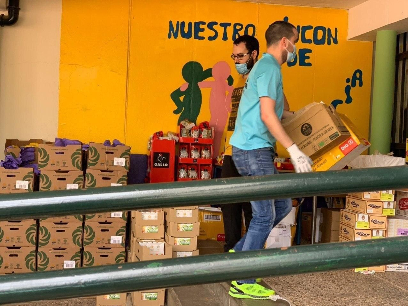 Voluntarios cargan cajas de comida para familias necesitadas. Voluntarios cargan cajas de comida para familias necesitadas.