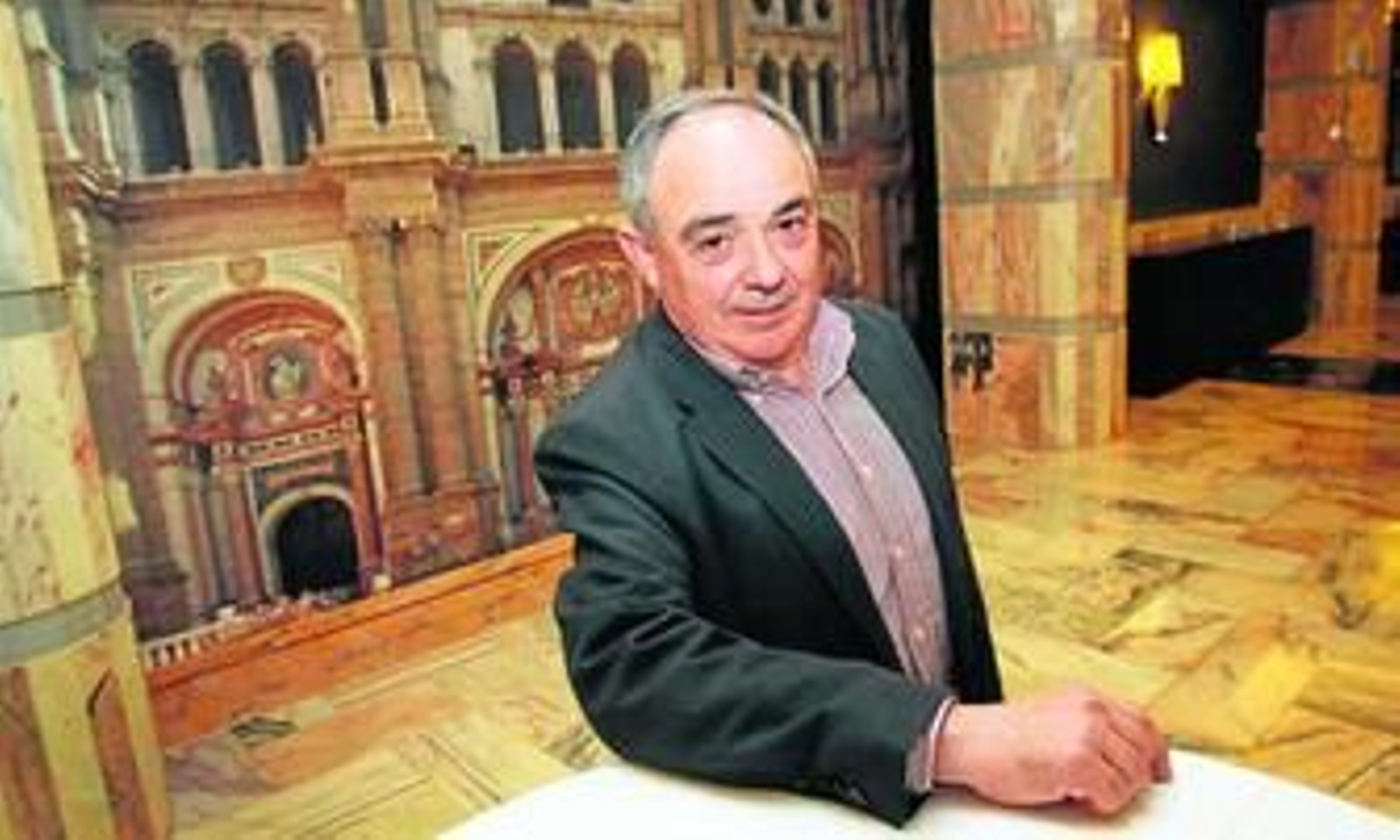 José Gómez posa en el restaurante Pórtico de Velázquez delante de una gran fotografía de la Catedral de Málaga.