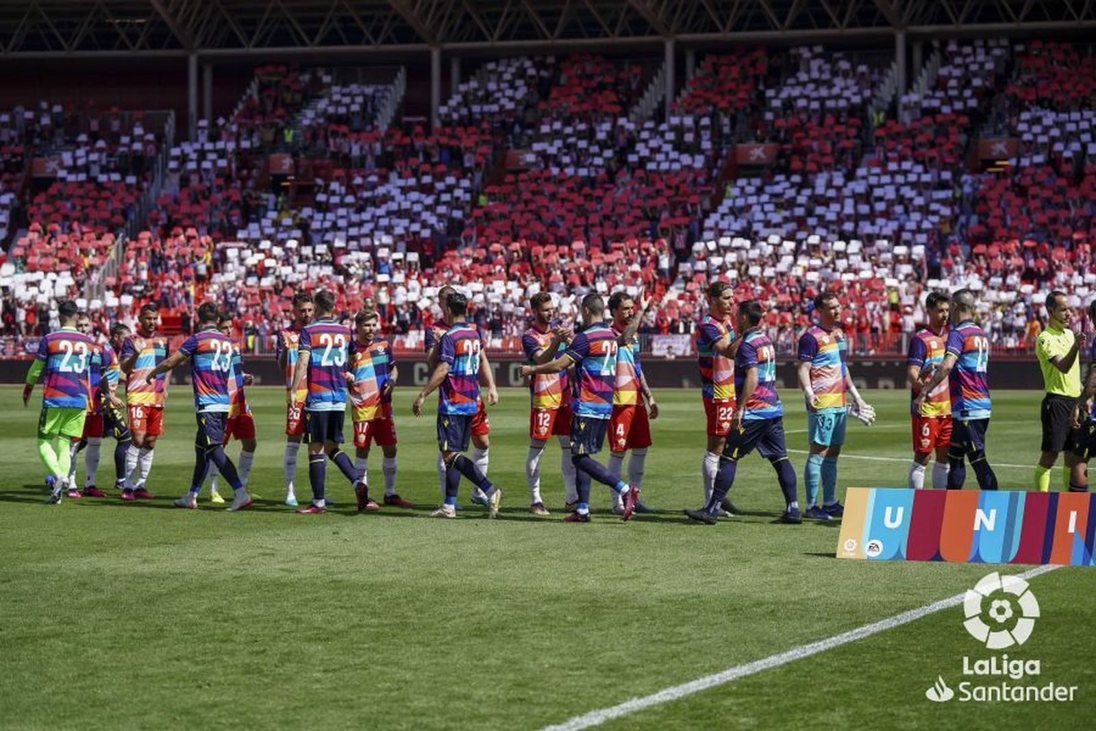 Ambos equipos se saludan, con un mosaico al fondo.