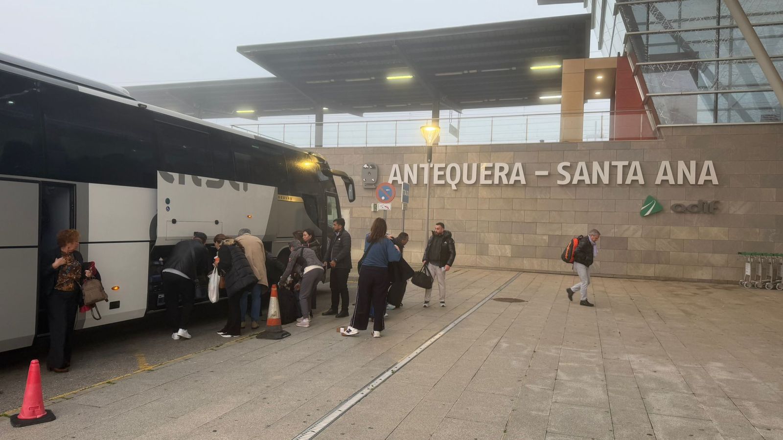 Viajeros bajan del autobús en Antequera Santa Ana para esperar al tren que les llevaría a Madrid.