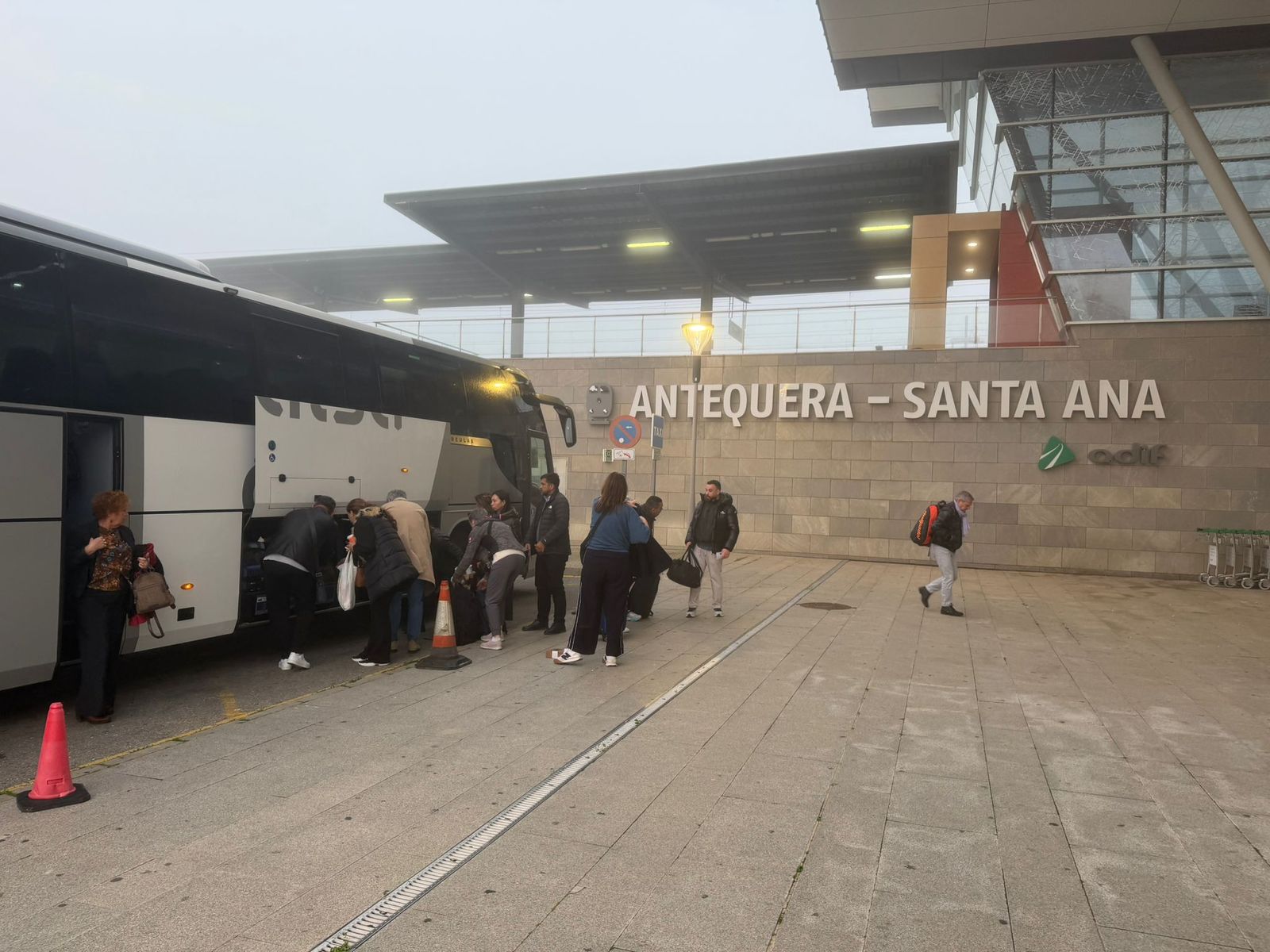 Viajeros bajan del autobús en Antequera Santa Ana para esperar al tren que les llevaría a Madrid.