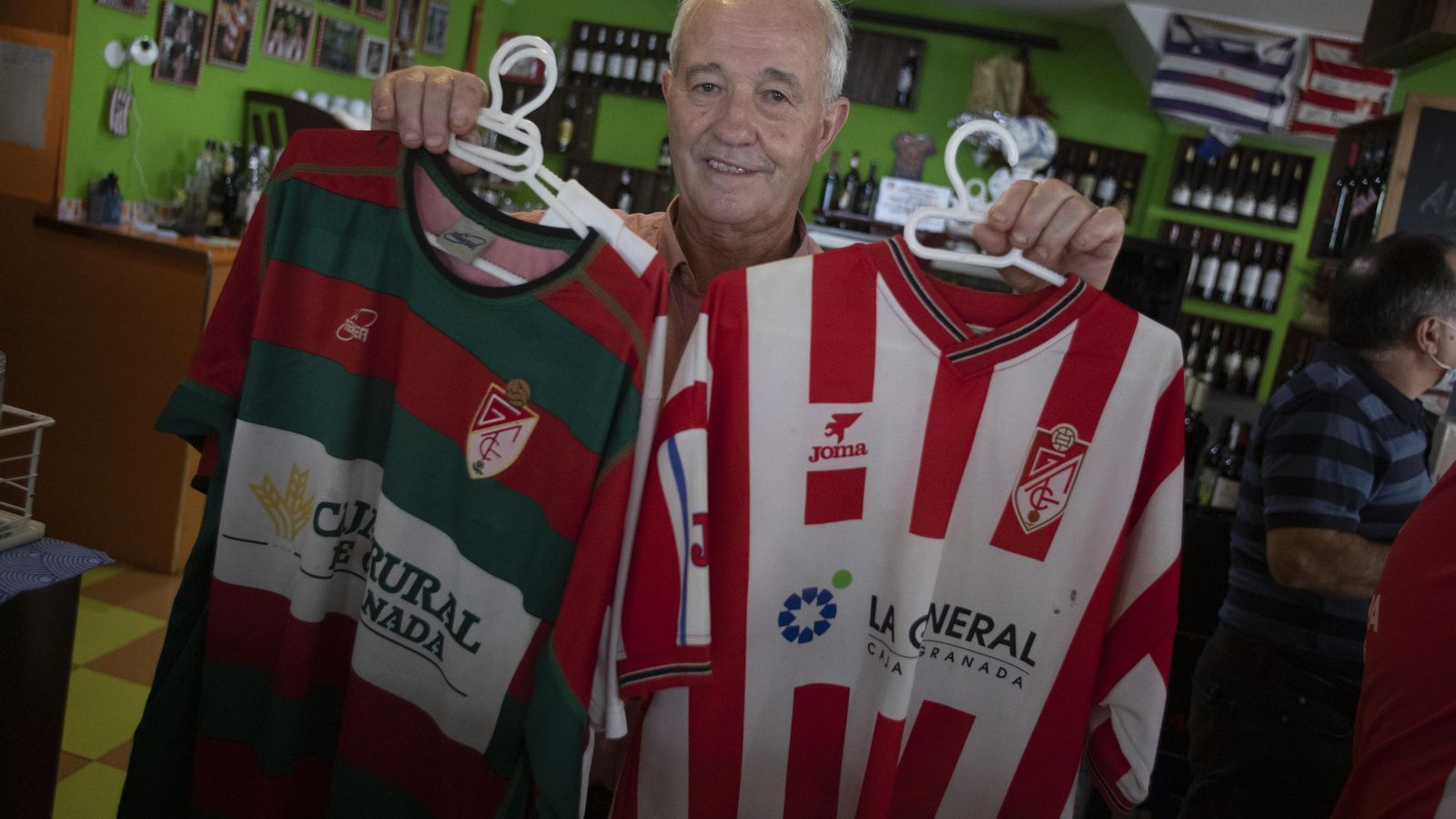 El dueño de la Taberna, Manolo, con algunas de sus muchas camisetas del Granada CF