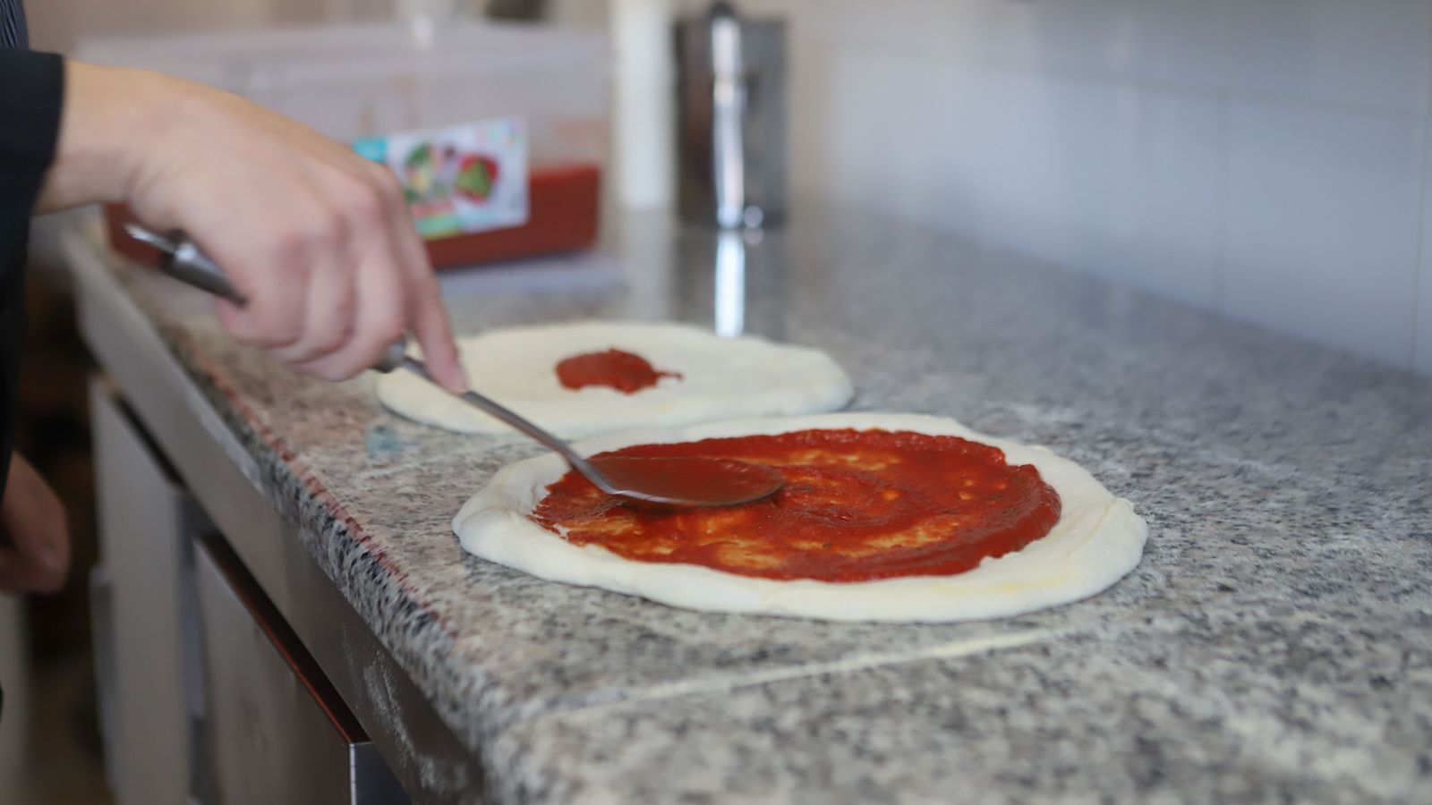 Salsa de tomate sobre la base de pizza